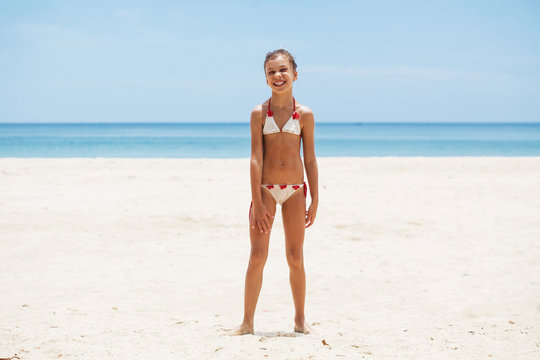 Юная девушка на пляже снимает трусики