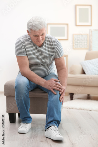 Mature Man Suffering From Knee Pain At Home Stock Photo And Royalty