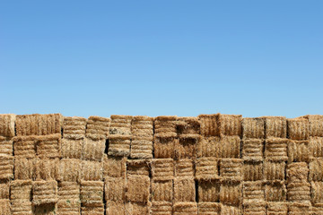 hay bales wall against blue sky