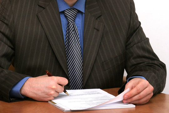 businessman is signing a document