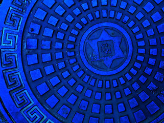 sewer cap in blue color with meander pattern