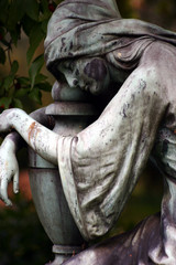 statue einer trauenden frau auf einem grab
