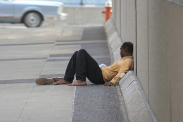 homless man laying on the ground looking away