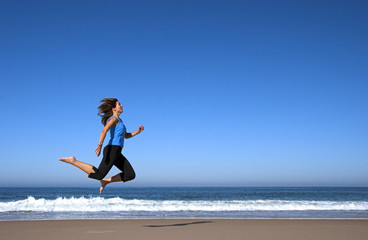 young woman runing and jumping in the beach