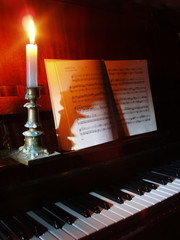 piano and sheet music in the candle lighting