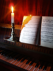 piano and sheet music in the candle lighting