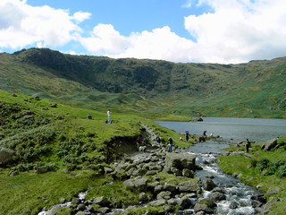 walkers resting by a tarn in the lake district
