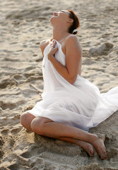 Fototapeta na wymiar woman in white clothes sitting on the beach