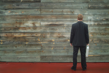 business man facing a wall