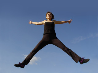 young woman jumping high in the sky
