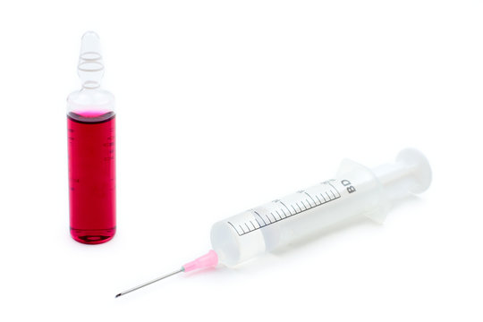 syringe and ampula against white background