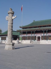 statue and flag in front of chinese building