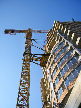 tall orange crane constructing building