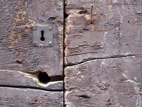 keyhole and cracks in wooden door