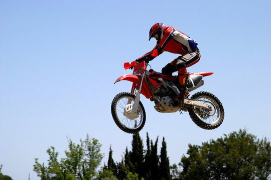 moto x or motor cross bike leaping through the air on a hot sunn