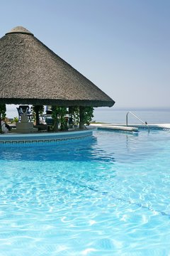 tiki hut and bar by swimming pool of luxury hotel