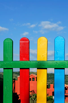 colourful rows of painted wood on a playground fence