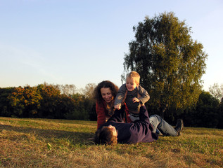 family plays autumn on sundown on glade