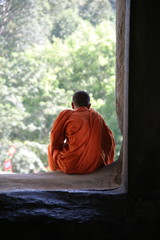 a monk sits and thinks in the temple of angkor wat