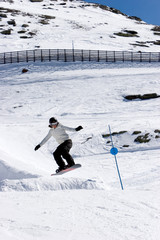 man snowboarding on slopes of ski resort in spain