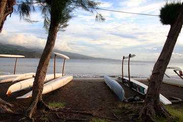 black sand beach with pirogues