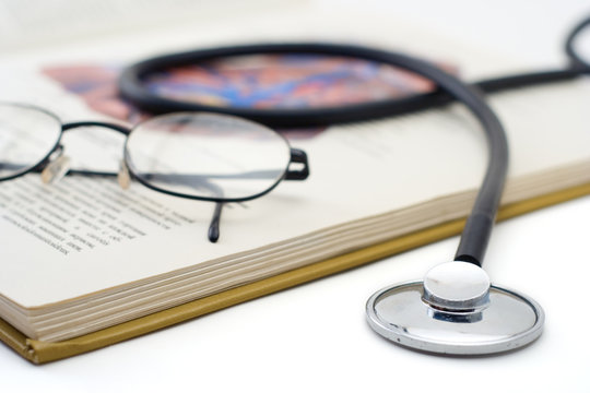 stethoscope and glasses on a book