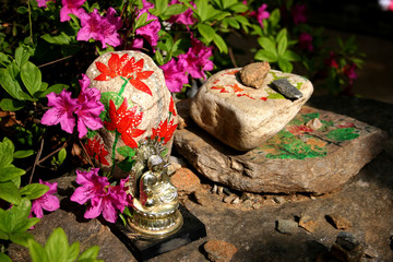 buddha image sitting on painted rocks