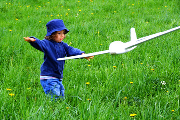 girl with airplane on the grass