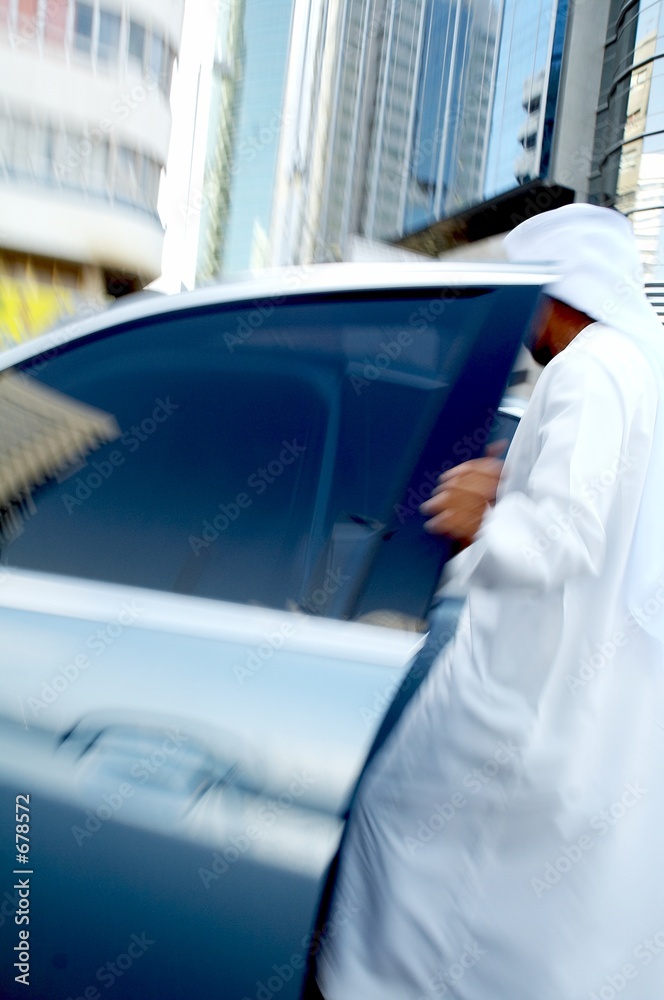 Wall mural men wearing disdasha and entering his car