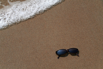Fototapeta na wymiar okulary przeciwsłoneczne w piasku