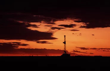 Foto op Plexiglas oil rig at sunset © Jim