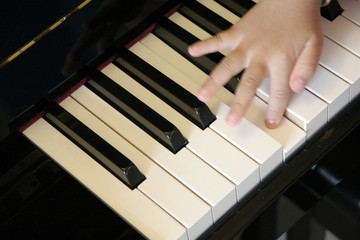 Fototapeta na wymiar ręce dziecka na klawiaturze fortepianu