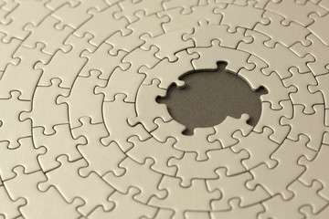jigsaw in sepia with missing pieces in the center
