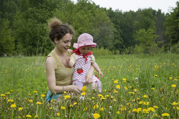mother with baby on meadow
