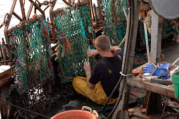 lad working on trawler fishing boat