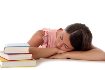 woman sleeping with head on desk next to stack of