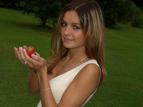 junge frau mit erdbeeren in der hand