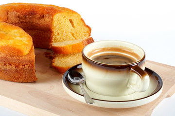 sponge cake with the cup of coffee and spoon on wo