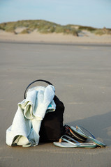 sac, serviette et tongue sur le sable