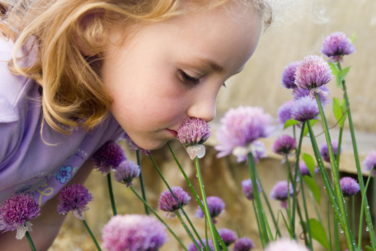young girl smelling flowers