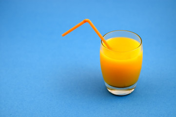 glass of orange juice with cockteil straw