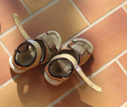 les sandalettes d'enfant posées sur la carrelage