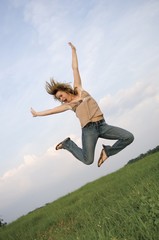pretty girl leaping in field