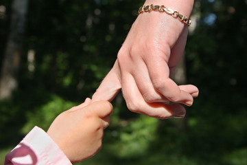 mother's  and baby's hands in park