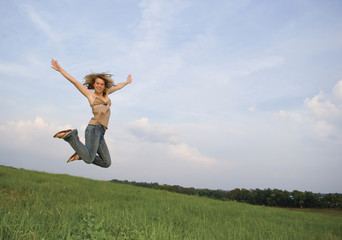 pretty girl leaping in field