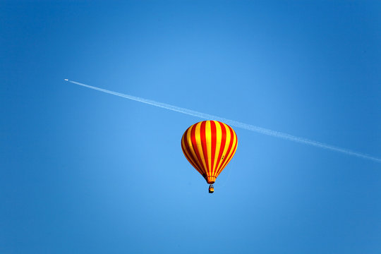 ballon and an airplane with slipstrem on the blue