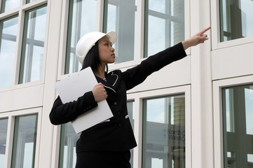young female engineer pointing at construction