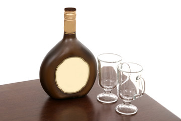 irish creme bottle and two empty glasses