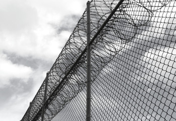 angle view of prison fence with razor wire
