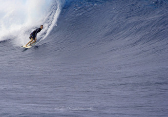 surfer goes left in big waves